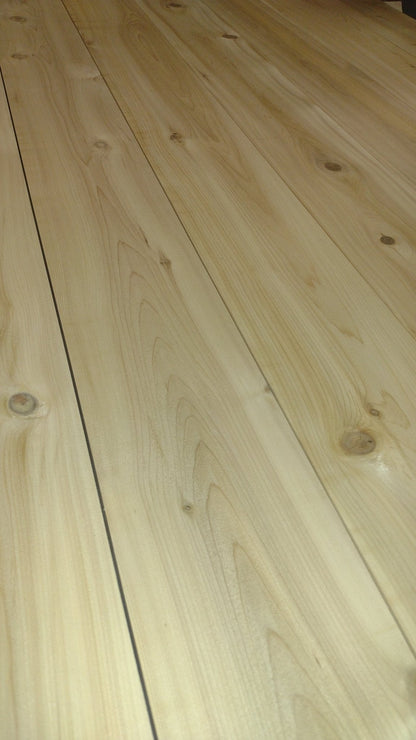 Light cedar tabletop surface with visible wood grain and plank seams