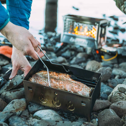 Portable metal fire pit box with legs and flame grill, open top with burning logs