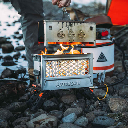 Metal portable fire pit with front mesh grate and burning flames, FIRECAN logo