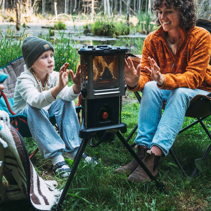 Portable heater stove on tripod with glowing heat panel and cookware on display
