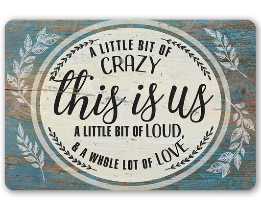 Blue metal sign with 'This is us' in wreath, 'A LITTLE BIT OF CRAZY' text.