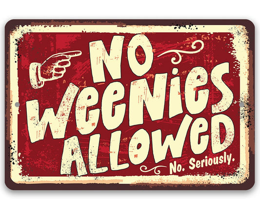 Red metal wall sign with cream border reading “No Weenies Allowed” with hand icon.
