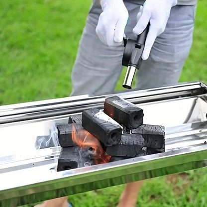 Fire blower nozzle directing airflow into charcoal in a grill tray