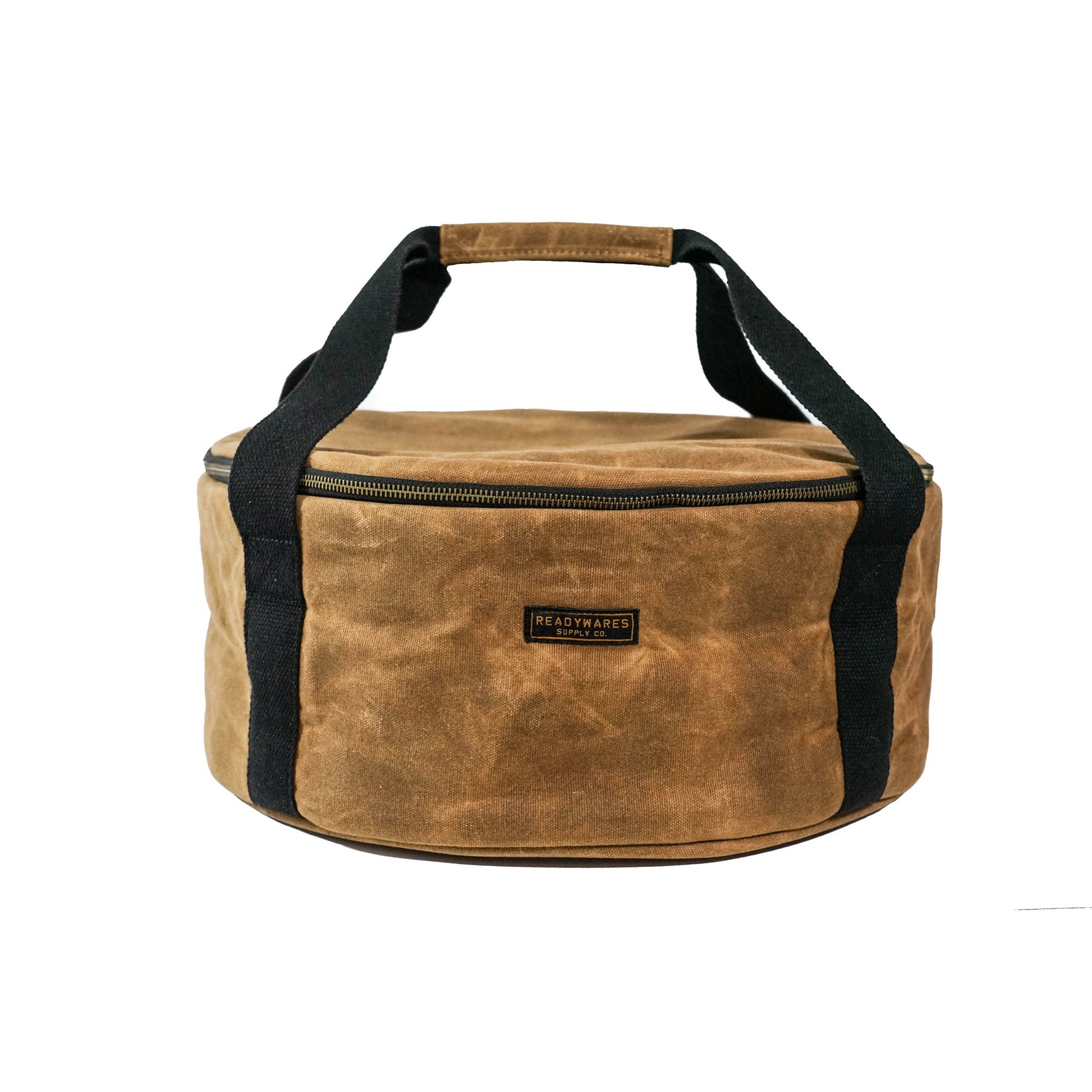 Insulated Dutch oven cover with tan fabric, black handles, and front logo patch