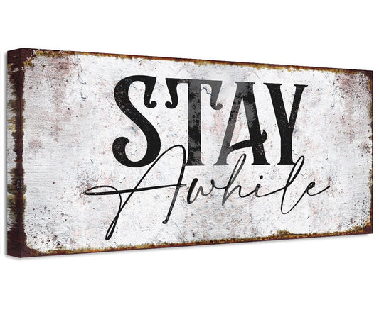 Stretched canvas wall art with distressed white and black “Stay Awhile” lettering