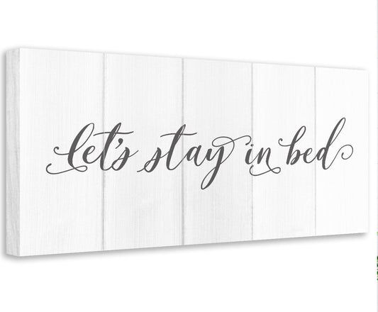 Stretched canvas with “Let’s stay in bed” script across white vertical panels
