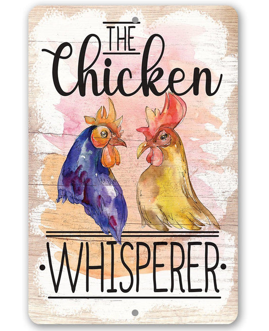 Metal sign with two illustrated chickens and text “The Chicken Whisperer.”