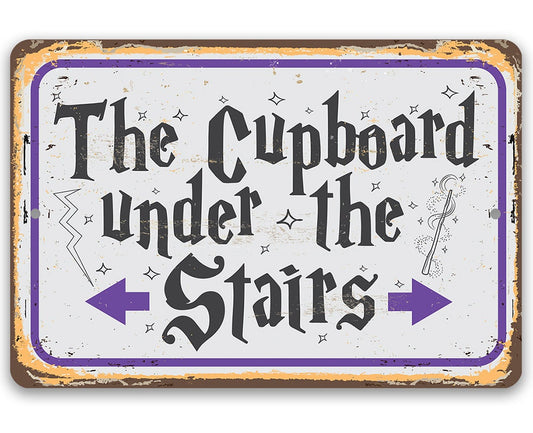 Metal sign reading "The Cupboard Under the Stairs" with purple border and arrows