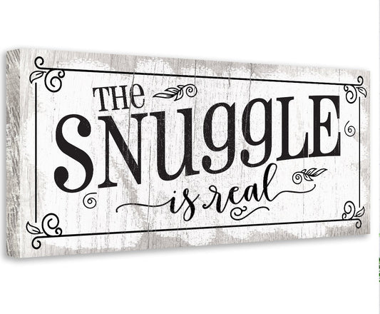 Stretched canvas wall art with “The Snuggle is real” black lettering on cream